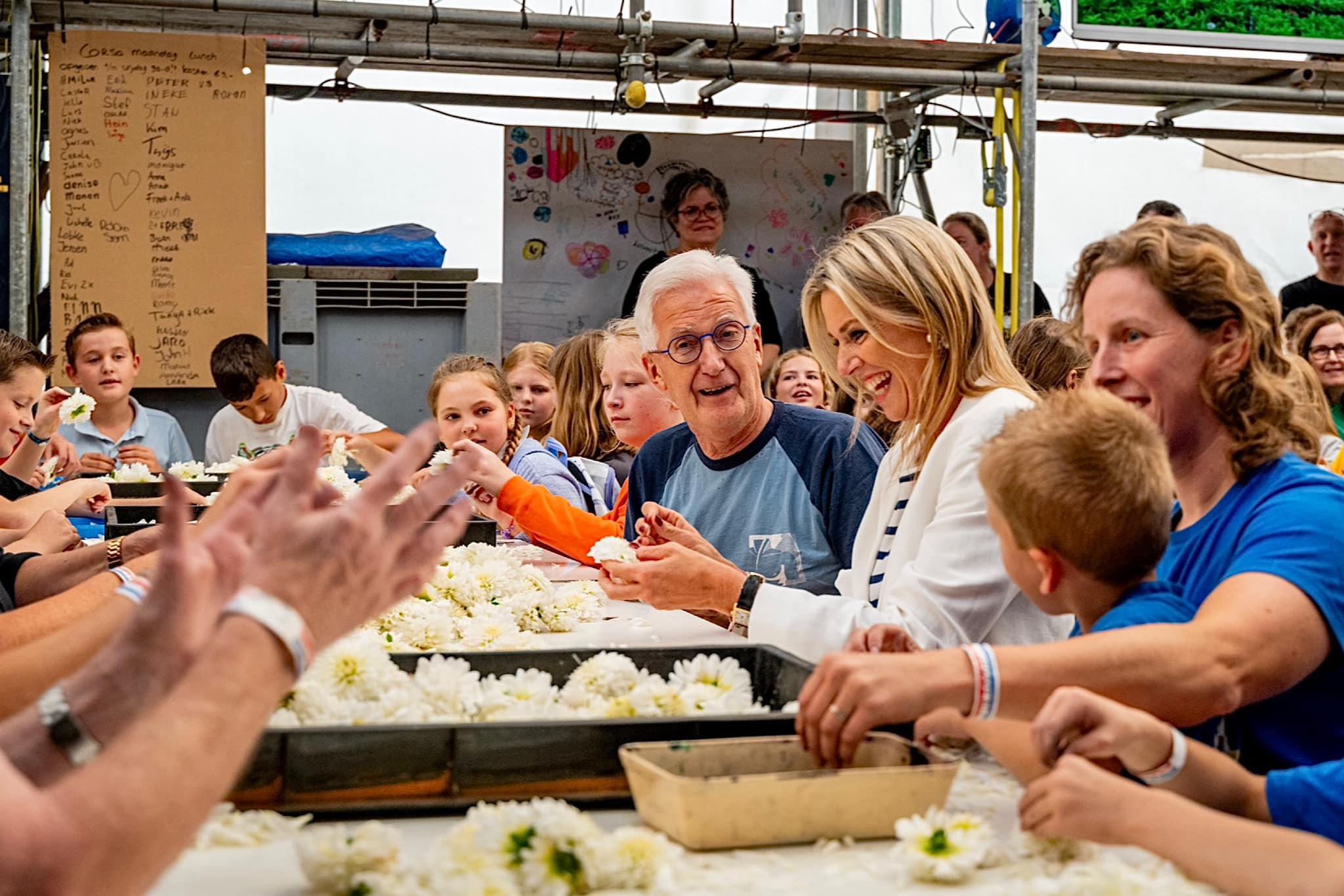 Koningin Máxima bezoekt de drie buurtschappen Helpt Elkander, De Berk en Klein Zundert tijdens de voorbereidingen van Corso Zundert 2024. Zij ontmoet vrijwilligers en gaat met hen in gesprek over de werkzaamheden en het belang van het corso voor Zundert en de onderlinge saamhorigheid. Ook helpt Koningin Máxima mee met het prikken en tikken van de dahlia’s.